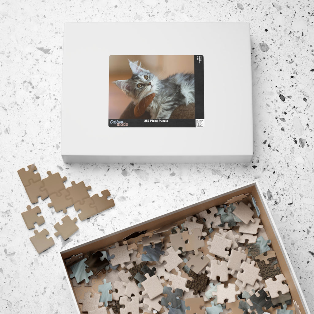 Boîte de puzzle et pièces en carton beige, visuel de chat gris sur l’emballage