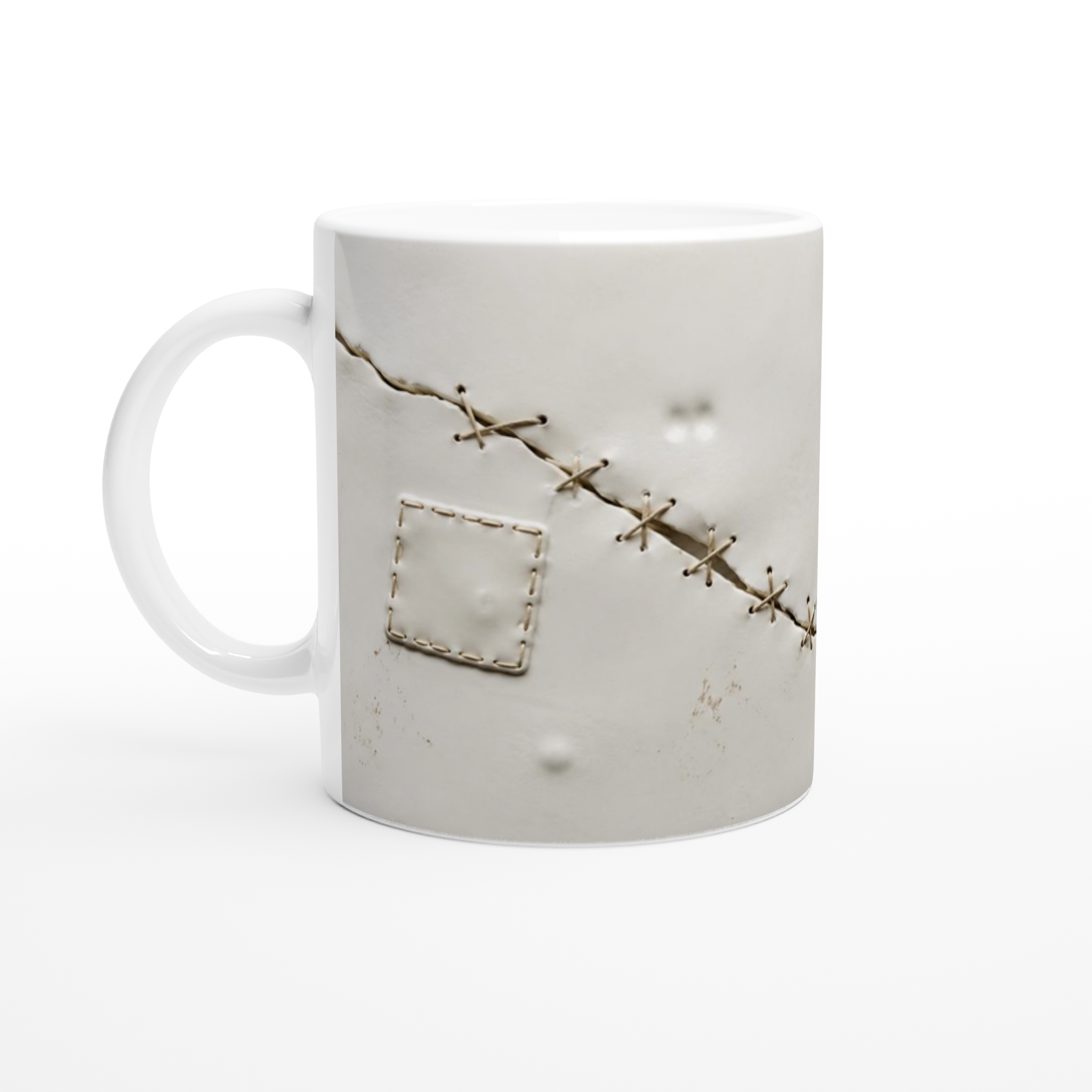 Mug blanc avec anse et décor de sutures, incluant un patch rectangulaire en trompe-l’œil.