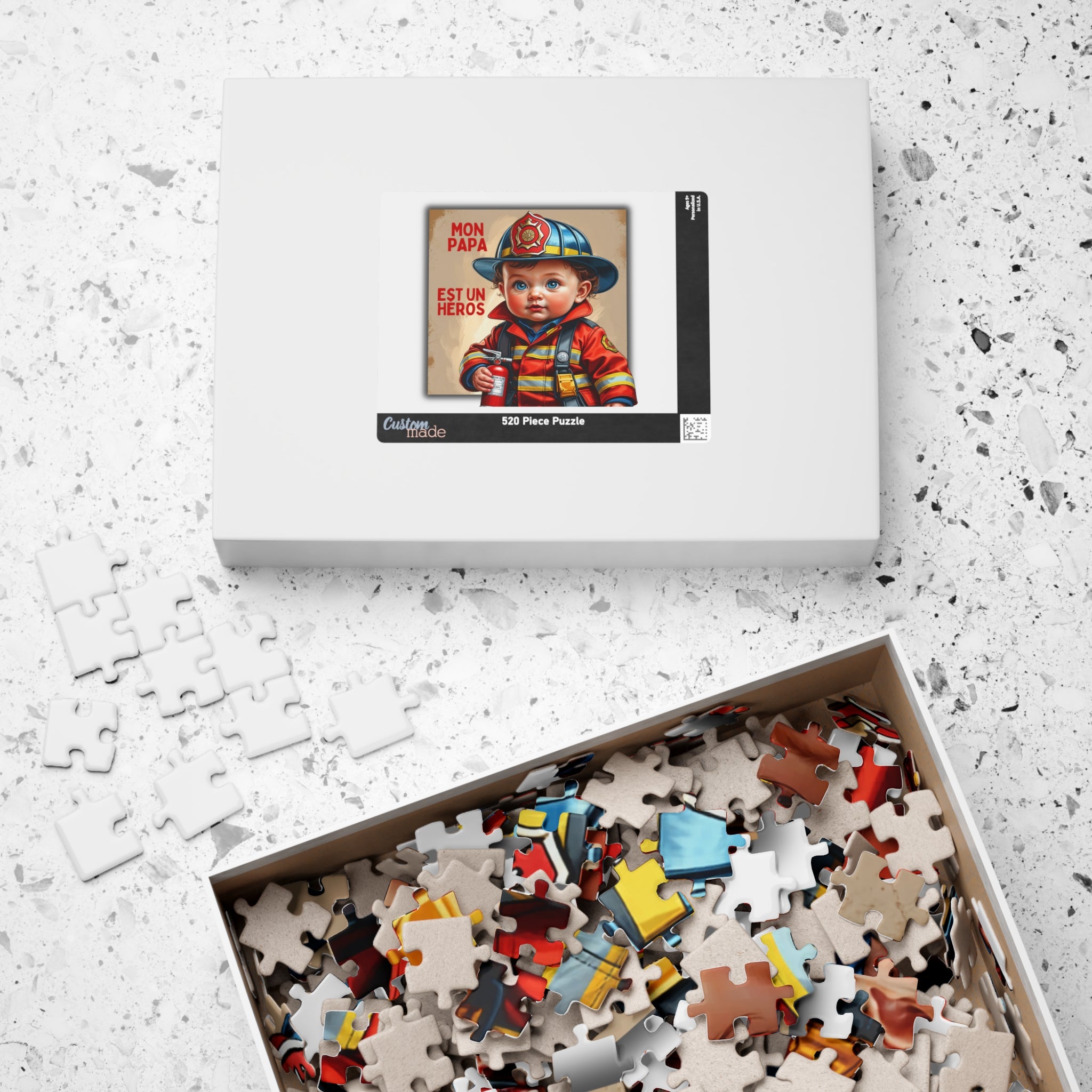 Boîte de puzzle ouverte avec nombreuses pièces au motif de bébé pompier