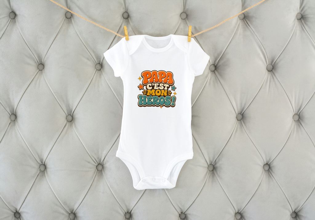 Body bébé blanc sur coussin capitonné, inscription « Papa c’est mon héros ! »