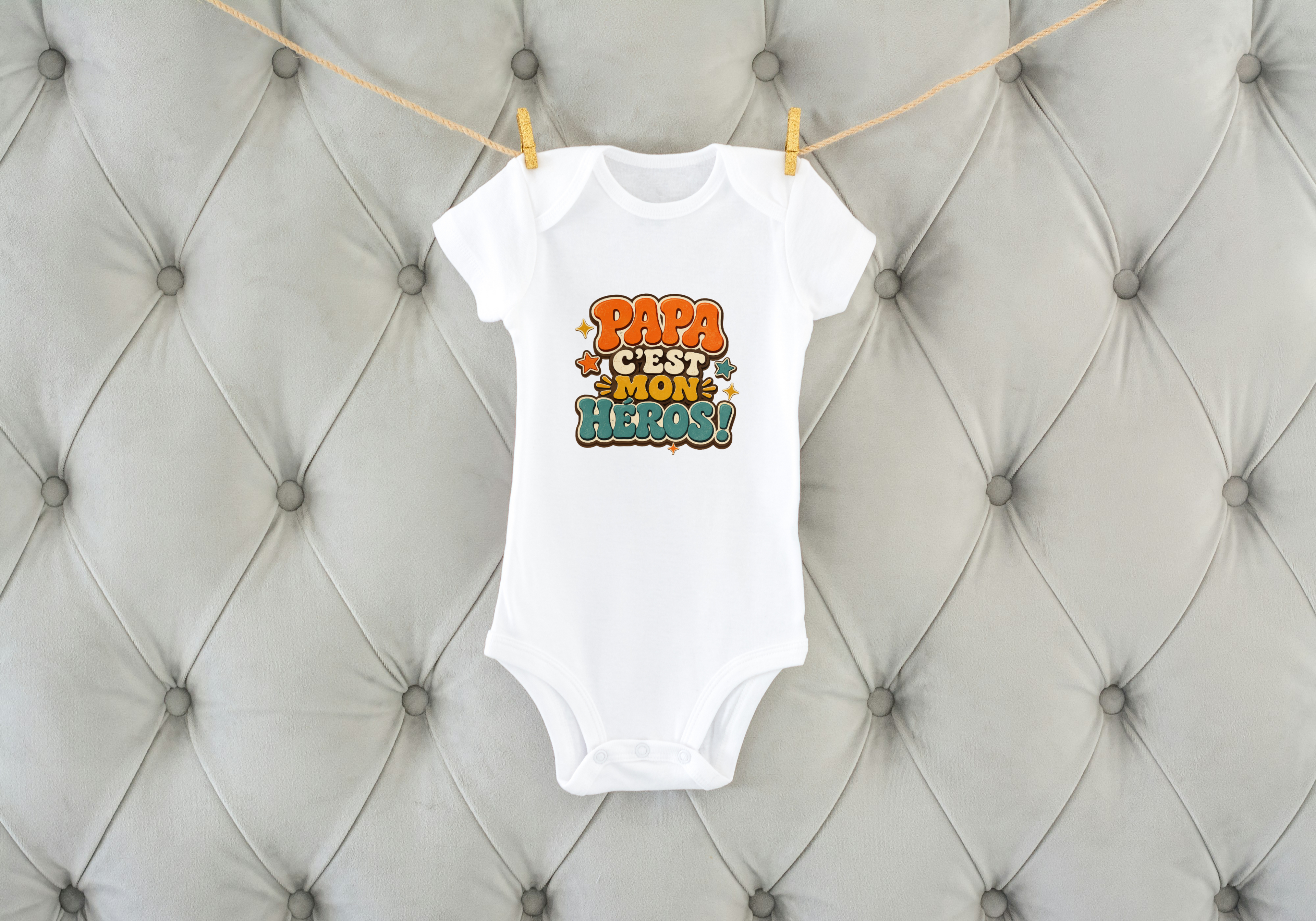 Body bébé blanc sur coussin capitonné, inscription « Papa c’est mon héros ! »