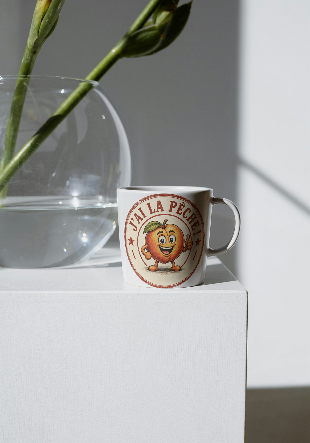 Mug en céramique blanche avec motif rond "J'ai la pêche" et personnage souriant.