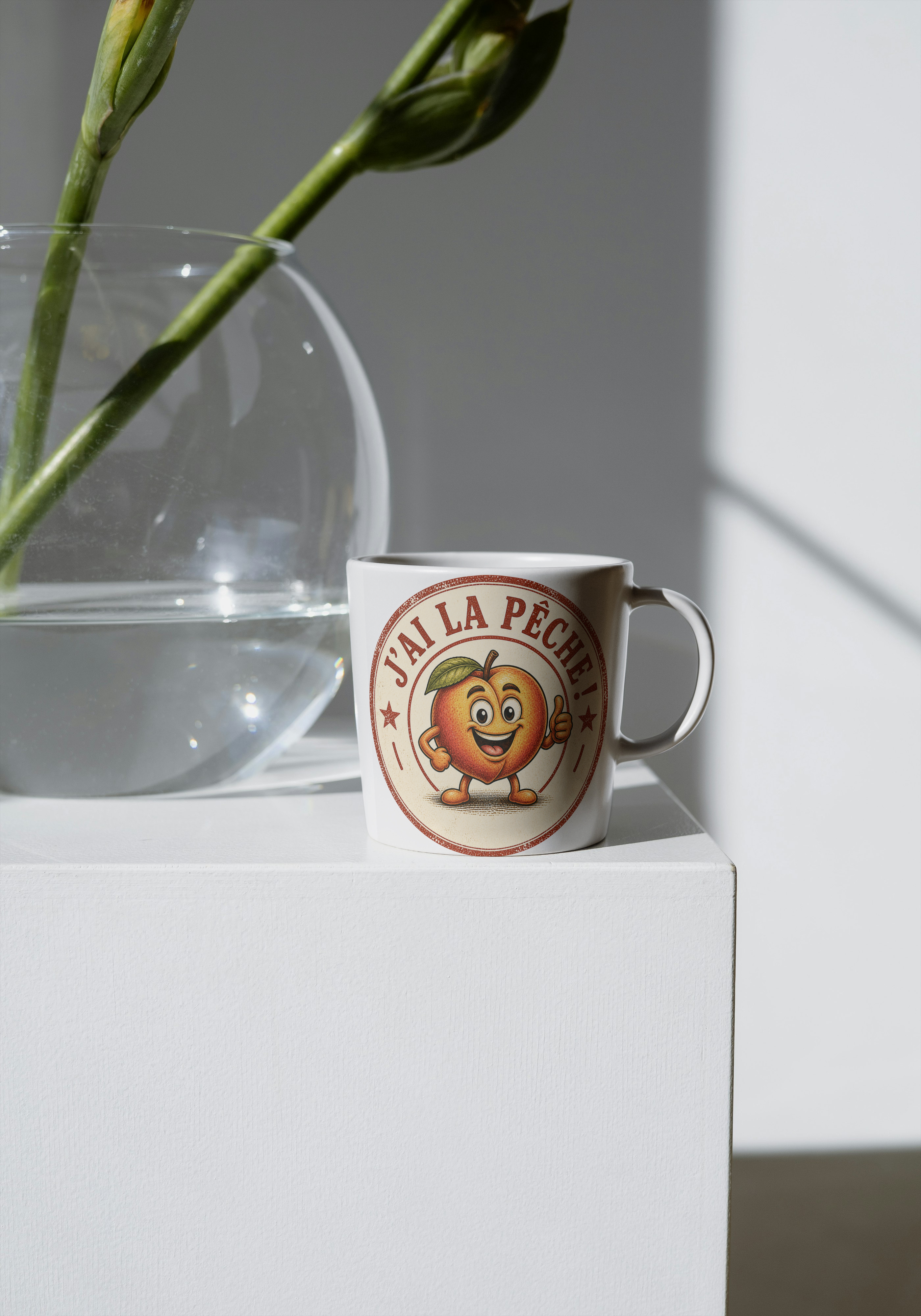 Mug en céramique blanche avec motif rond "J'ai la pêche" et personnage souriant.