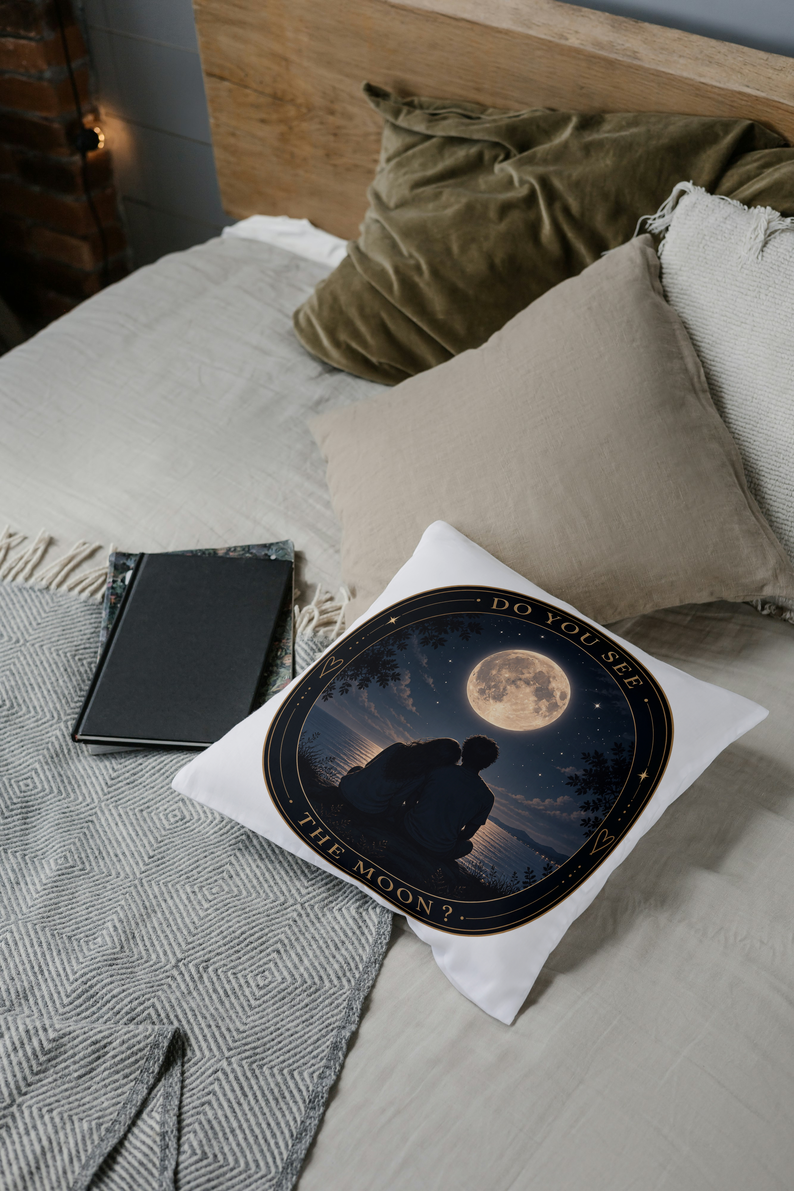 Coussin blanc avec motif lune et couple en silhouette sombre, bordure noire dorée