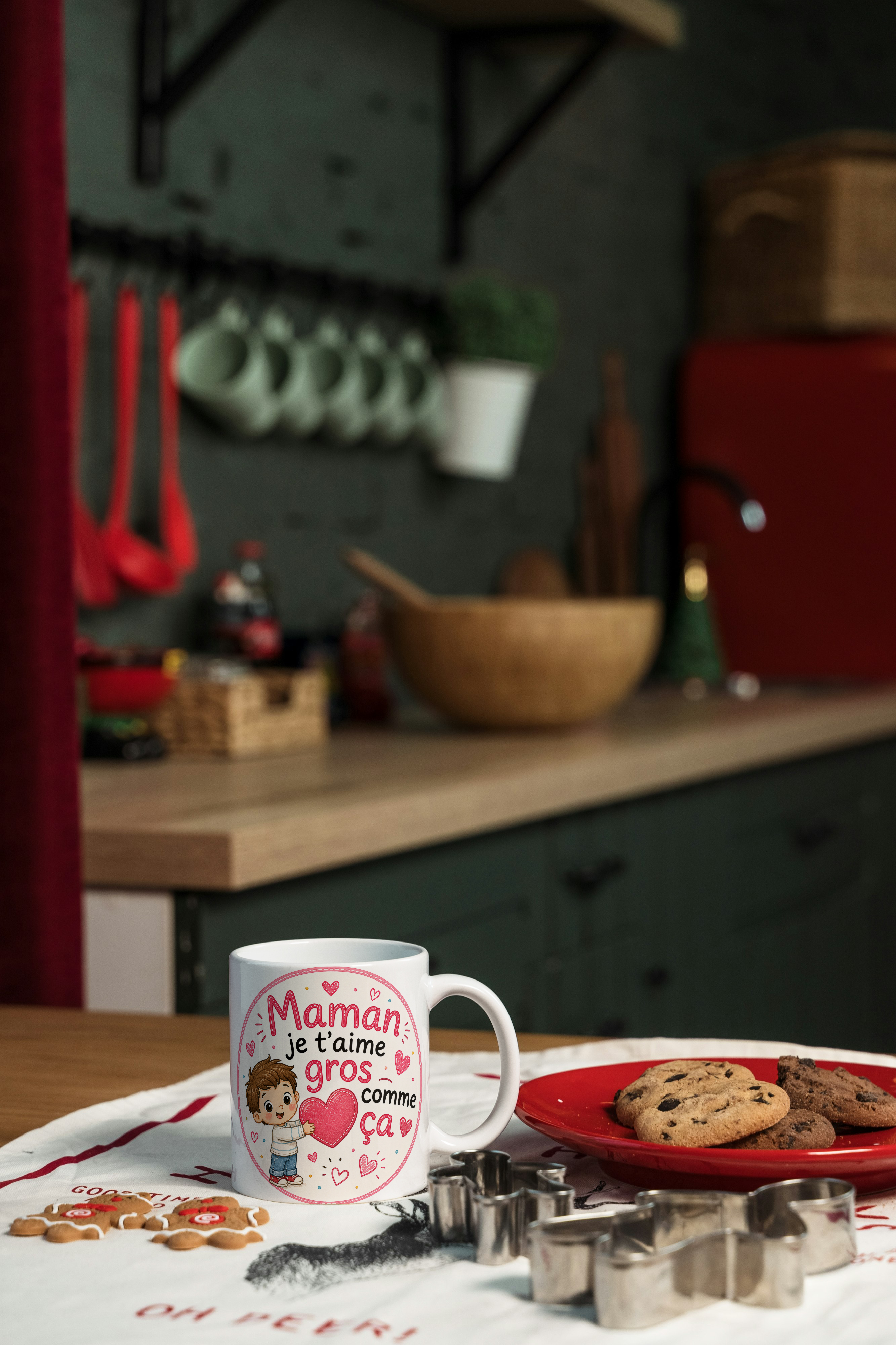 Tasse blanche « Maman je t’aime gros comme ça » sur comptoir, près de biscuits