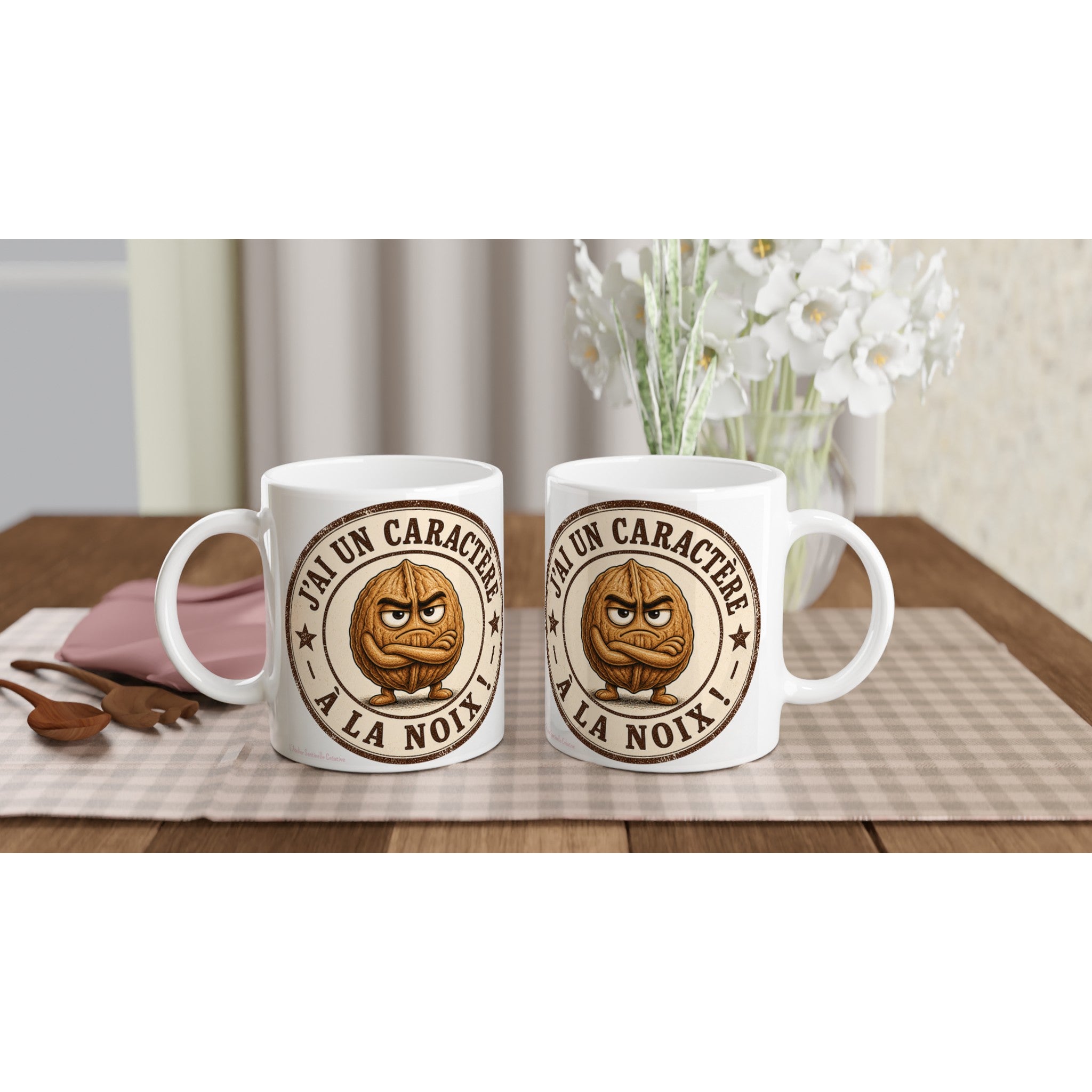 Deux mugs blancs avec poignées et logo rond « J’ai un caractère à la noix ».