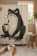 Rideau de douche beige avec grenouille noire tenant une tasse, vue rapprochée et décor de plantes.