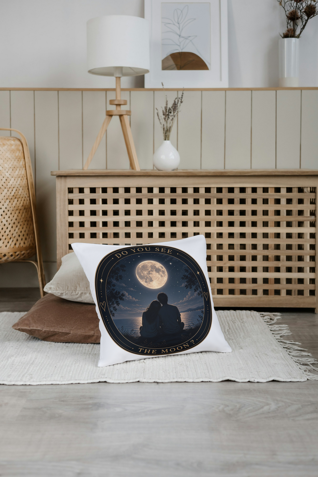 Coussin blanc avec motif lune et couple en silhouette, cercle noir bordé d’or