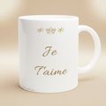 Mug blanc avec inscription dorée « Je t’aime » et couronne au centre.
