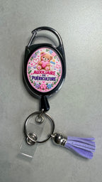 Porte-badge noir avec badge Auxiliaire puériculture, mousqueton métal et pompon violet