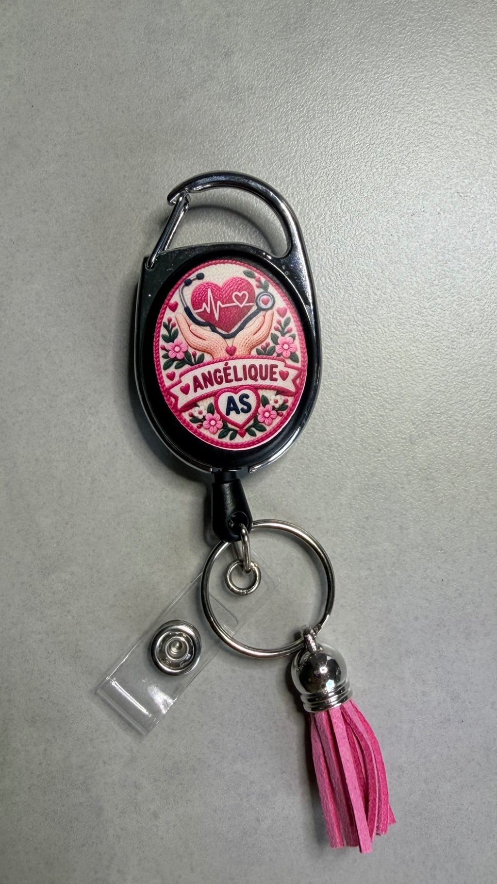 Porte-badge noir avec badge cœur rose, attache métal et pompon rose