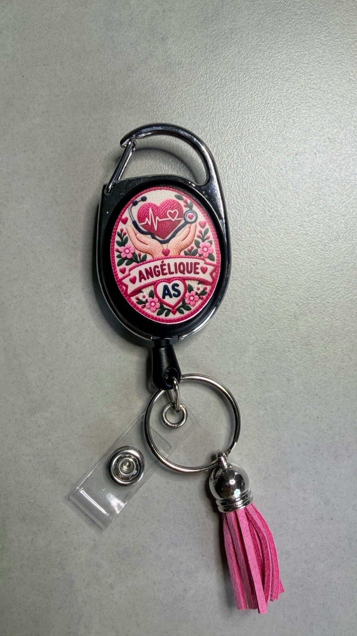 Porte-badge noir avec badge cœur rose, attache métal et pompon rose