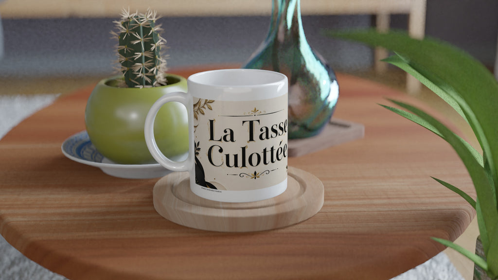 Mug blanc avec poignée, texte « La Tasse Culottée » sur fond crème
