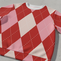 Détail du pull : motif argyle en losanges rouge, rose et blanc, col gris clair