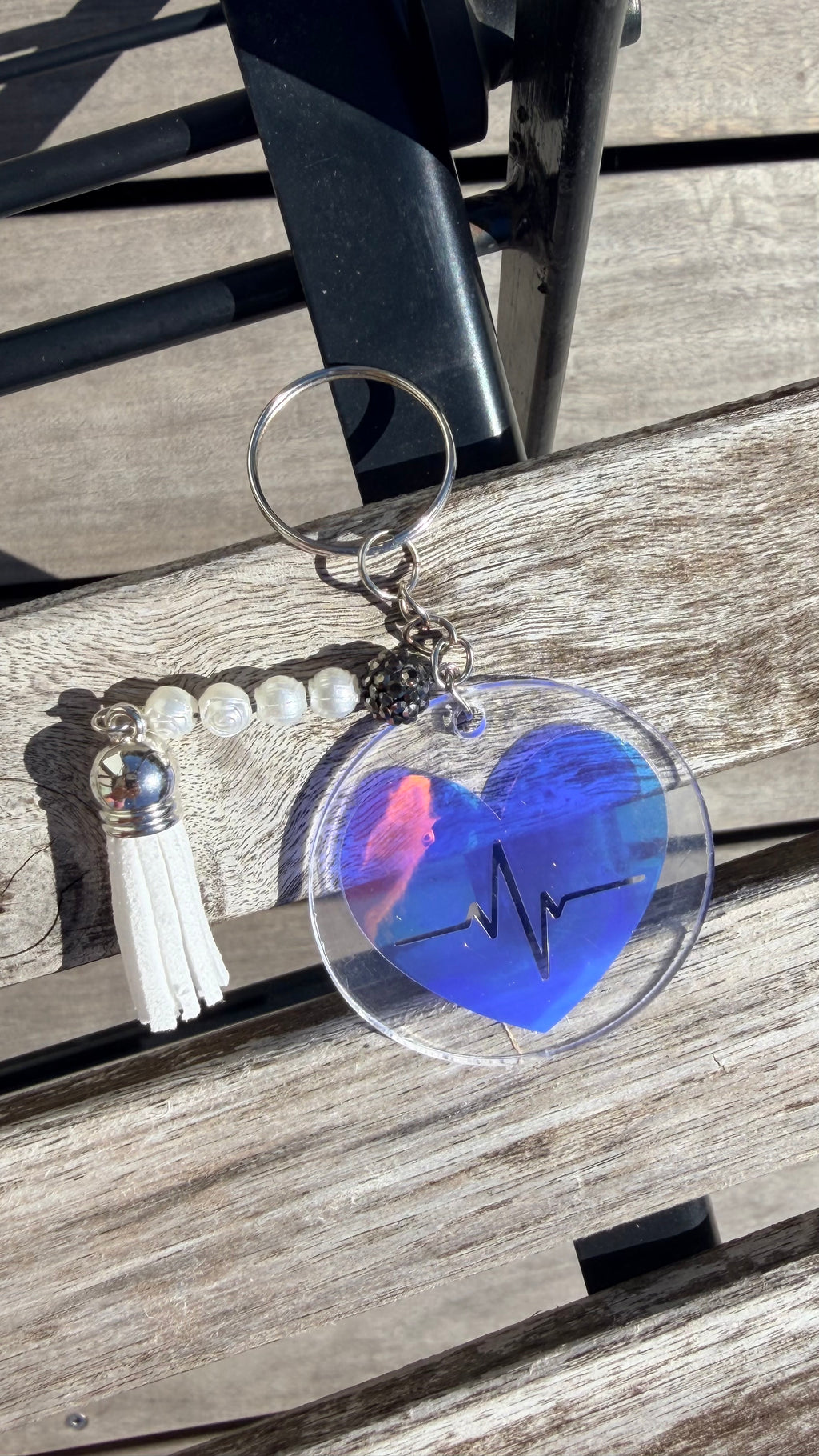 Porte-clés cœur irisé bleu ECG, pompon blanc et perles sur porte-clés argenté.